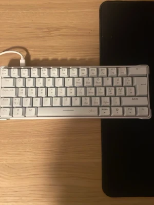 Xtrfy RX5 Micro TKL White - Kompakt och stilren Xtrfy RX5 Micro TKL tangentbord i vitt utförande. Mekaniska brytare, USB-anslutning och nordisk layout. Tangentbordet är i gott skick utan synliga defekter eller slitage. Perfekt för gaming eller arbete där platsbesparing är viktigt.