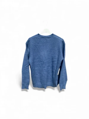 Blå stickad tröja  - En enkel och snygg blå stickad tröja med rund hals och ribbade muddar vid ärmslut och nederkant. Perfekt för dig som gillar en klassisk look och vill ha något mjukt och bekvämt. Passar till jeans eller chinos och är lätt att matcha med andra plagg.