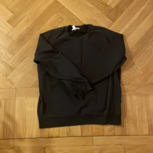 Marinblå sweatshirt i bomull - Nu har det blivit dags att sälja min stilrena marinblå sweatshirt med rund hals och långa ärmar. Tröjan har en klassisk passform och är tillverkad i mjuk bomull, perfekt för chill dagar. Ribbstickade muddar vid ärmslut och nederkant ger en snygg finish. Några tecken på användning men har fortfarande mycket att ge. OBS tröjan är i storlek A11 men sitter som S