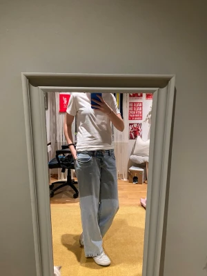Blå wide jeans med låg midja - Säljer ett par ljusblå jeans med låg midja och vida ben från Gina tricot. Jeansen har klassiskt femfickmodellen, med en urtvättad blå färg. Säljer jeansen då dem inte kommer till användning. Byxläng cirka 1,70 och midje mått 82cm. Pris kan diskuteras och svarar gärna på frågor 💗