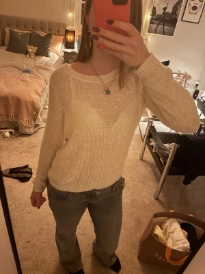 Krämvit stickad tröja från Only - En krämvit stickad tröja från Only med rund halsringning och långa ärmar. Tröjan har en enkel, klassisk design med ribbade muddar vid ärmslut och nederkant. 