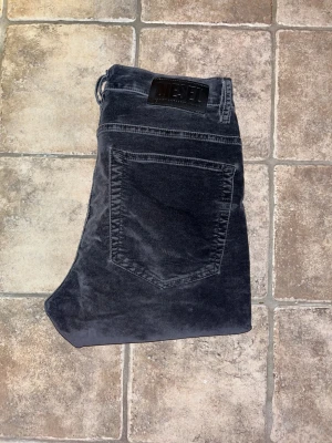 Diesel jeans - Säljer dessa svarta skinny jeans från Diesel, modell D-Amny. Byxorna är gjorde i sammet matrial. Jeansen har en smal passform hela vägen ner. Perfekta för dig som gillar en tajt siluett och vill ha en cool look. Midja 36cm, längd 102. JAG SKICKAR EJ FLER BILDER NÄR JAG BÄR JEANSEN! för storleksguide hänvisar jag till måtten och för bättre inblick i passformen rekommenderar jag att googla på modellnamnet :) OBS tyvärr fått leveransskador och på ett ställe blivit sytt - se sista bild. !!
