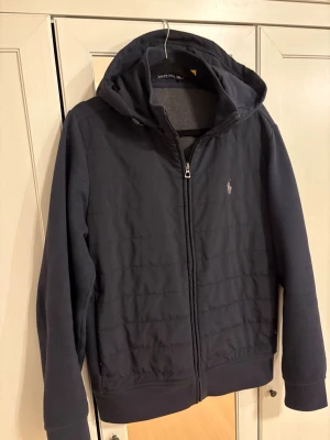 Polo Ralph lauren cardigan  - Snygg svart pufferjacka från Polo Ralph Lauren med huva och dragkedja framtill. Nypris runt 4 tusen, passar bra på mig som är ish 180