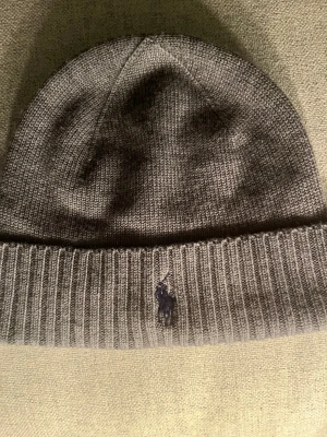Grå mössa Polo Ralph Lauren - Säljer en fett mössa från Polo Ralph Lauren, som aldrig är använd!!! 🔥🔥 Perfekt for kalla dagar❄️☃️ Enkel att matcha med olika outfits. Tillverkad i mjukt och värmande material. 🎅 Tveka inte på att höra av dig vid frågor! 📲