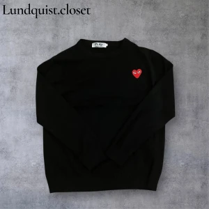 Svart tröja från Comme des Garçons - Svart stickad tröja från Comme des Garçons PLAY med ikoniskt rött hjärta på bröstet. Rund hals och långa ärmar. Storlek L men passar bättre som storlek M