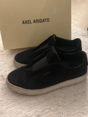 Svarta sneakers från Axel Arigato - Ett par äkta svarta Arigatoskor med vit sula i storlek 41. I mycket bra skick, ser lite dammiga ut på bilden då jag inte tvättat dem. Tvättar dem innan jag skickar iväg dem till dig!:) Det ingår originallåda samt påsen de kom i. 