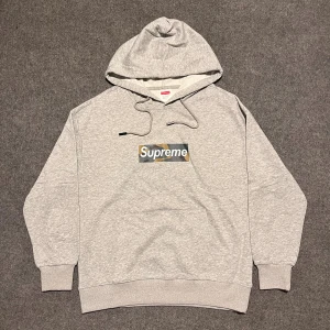 Supreme Grå hoodie - storlek S - Grå Supreme-hoodie i mycket bra skick. Mjukt material, bekväm passform och en stilren camo box logo. Pris kan diskuteras. Snabba svar och snabb frakt – tveka inte att höra av dig vid frågor. Längd: 65 cm, bredd: 52 cm.