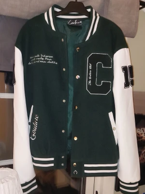 College Jacka - Säljer en grön vit college jacka som jag inte längre använder, den är lite för stor för mig.