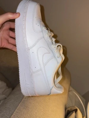Nike Air Force 1 vita sneakers - Säljer ett par klassiska Nike Air Force 1 sneakers endast använda 2 gånger och är fortfarande i nytt skick.