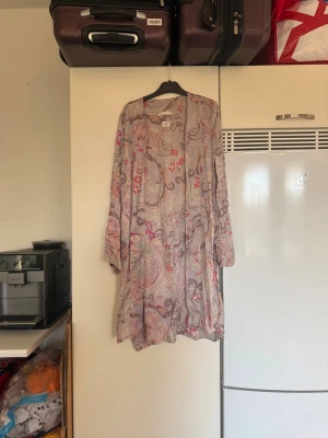 Blommig omlottkofta Odd Molly - Säljer en långärmad omlottkofta från Odd Molly i storlek 1. Koftan har ett blommigt mönster i lila, rosa, beige och röd ton, med tunna och luftiga material. Perfekt för dig som gillar bohemisk stil och vill ha något unikt i garderoben. Storlek 1 som enligt deras storleksguide motsvarar en S. Mer använd men fint skick, kan finnas något liten tråddragning. 