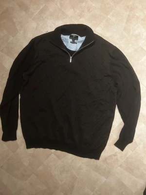 Svart half zip tröja Fynch Hatton XL - Svart långärmad tröja från Fynch Hatton i storlek XL. Tröjan har ett diskret mönster på framsidan, hög krage och half zip-dragkedja. Tillverkad i superfine bomull för en mjuk och skön känsla. Perfekt för dig som gillar stilrena och klassiska plagg.