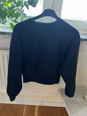 Mörkblå sweatshirt från Gina Tricot - Säljer en enkel och stilren mörkblå sweatshirt från Gina Tricot i storlek 170. Tröjan har långärmade ärmar, ribbade muddar och är tillverkad i mjuk bomull med fleece på insidan. Perfekt för chill dagar och passar till jeans eller mjukisbyxor.