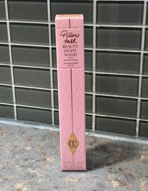 Charlotte Tilbury Pillow Talk Highlighter - Säljer en Pillow Talk Beauty Light Wand highlighter från Charlotte Tilbury. Kommer i en lyxig rosa förpackning med quiltad design och guldiga detaljer. Innehåller 12 ml flytande highlighter som ger en glowig finish. Färg 2 medium.