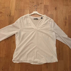 Vit v-ringad blus från Esprit  - Säljer en stilren vit blus från Esprit med v-ringning och långa ärmar. Storlek XL men är något mindre i storleken och skulle även passa en som har L. Blusen har en mjuk och lätt känsla, perfekt för en clean och fräsch look. Passar dig som gillar enkel och tidlös stil.