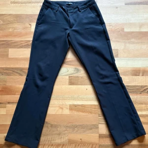 Svarta kostymbyxor från BikBok - Svarta kostymbyxor från BikBok i klassisk rak modell. Byxorna är i low waist modell. Perfekta för en clean och stilren look. Materialet känns mjukt och följsamt. Ett litet hål längst ner vid ena byxbenet, syns inte när man använder byxorna💗