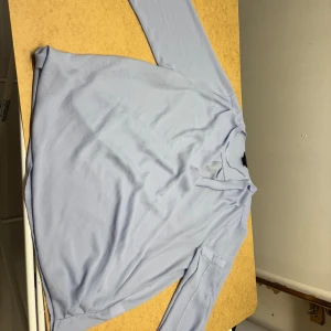 Ljusblå blus - En ljusblå fin långärmad blus i storlek 44.