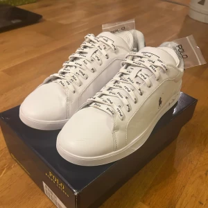 Vita sneakers Polo Ralph Lauren - Säljer vita Polo sneakers då jag köpte dem för en skolavslutning och märkte att skorna inte matchade mina outfits.                                        Bara använt dem 4-5 gånger efter det.                  Snörena är vita med Polo loggan på överallt men man fick även med 2 helt vita snören när jag beställde skorna som jag inte har tagit ut ur påsarna alls, ingår såklart.                                           Undersidan lite smutsig men inga hål eller nåt märkvärdigt. Skriv för fler bilder