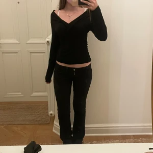 Svart omlottopp med offshoulder - Snygg svart omlottopp med offshoulder och långa ärmar. Toppen har en figurnära passform och en djup v-ringning som ger en trendig look. Man kan även ha över axlarna å är super gullig passar verkligen med allt💓💓