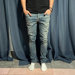 Blå jeans från Nudie Jeans stl 30/32 - Säljer ett par klassiska blå jeans från Nudie Jeans Co i storlek 30/32. Jeansen har en snygg tvätt, raka ben och coola detaljer på bakfickorna. Perfekta för dig som gillar en stilren och avslappnad look.