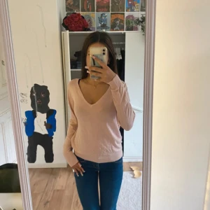 Ljusrosa v-ringad tröja från 157 - Säljer en ljusrosa v-ringad tröja från 157. Tröjan har lång ärm och är i ett tunt, mjukt material som känns skönt mot huden. Enkel och stilren modell som är lätt att matcha. Perfekt för lager-på-lager under hösten eller våren.