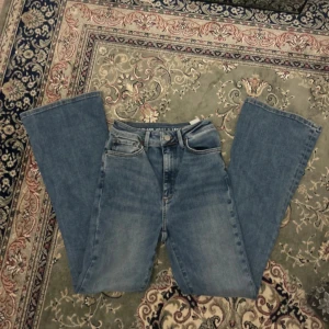 Blå bootcut jeans från carlings - Säljer ett par klassiska blå jeans från carlings med flare-modell. Jeansen har fem fickor, normal midja och är tillverkade i ett mjukt denimtyg. Perfekta för dig som gillar en retro vibe och vill ha ett par jeans med lite vidare ben.