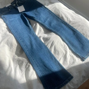 Mörkblå utsvängda jeans  - Riktigt snygga mörkblå utsvängda jeans ifrån Bikbok, helt i nyskick med prislapp kvar, då de var försmå för mig, perfekta i längden för dig som är 160cm!! Nypris låg på 500kr