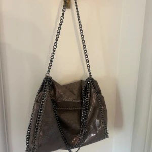 Grå kedje väska med glitter tyg  - Jätte fin väska säljer då jag tyvärr inte använder den längre. Originalpris 4000kr 