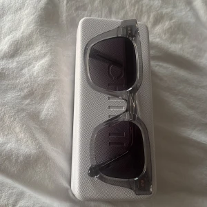 Grå solglasögon CHIMI - Säljer ett par stilrena solglasögon från CHIMI med transparent grå båge och fyrkantig form. Modellen 04, kommer med originalfodral och förpackning. Använda 1-2 gånger. 