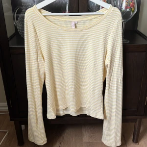 Gul och vit randig tröja  - Säljer en söt randig tröja från Nelly. Använd men är i ett jättefint skick. Tröjan har långa ärmar och har ett tunt material💛