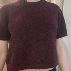 Stickad kortärmad vin röd tröja  - Tröjan är vinröd och har en rund halsring samt lite kortare i längden. Perfekt för en mysig höstdag, den är köpt från Gina tricot. Den var köpt för ca 180-200 kr men säljer för 90 kr❣️