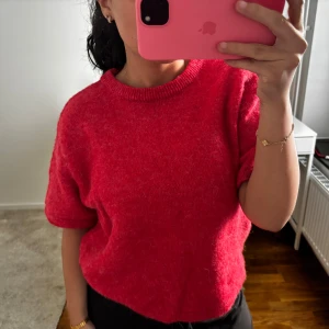 Röd stickad tröja från Gina Tricot - Supermjuk röd stickad tröja från Gina Tricot med korta ärmar och rund halsringning. Perfekt för dig som vill ha en enkel men ändå färgstark look. Tröjan har en lite loose passform och är riktigt skön att bära.