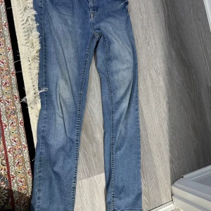 Blå jeans från Denim 1953, stl 40 - Snygga blå jeans från Denim 1953 i storlek 40. Klassisk femficksmodell med normal passform och raka ben. Jeansen har en lätt tvättad look och är tillverkade i mjukt denimtyg med dragkedjegylf och bälteshällor.