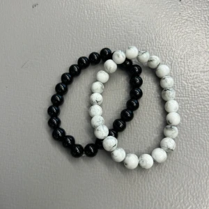 Svart och vit pärlarmband duo - Två elastiska armband med runda pärlor, ett i blankt svart och ett i vit marmorlook med grå ådring. Perfekt att bära tillsammans eller var för sig för en stilren och trendig look. Passar både tjejer och killar som gillar minimalistiska accessoarer. Passar handleder som är runt 15-17 cm, om ni har frågor är det bara att ta kontakt🙌