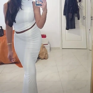 Vit set med crop top och kjol strl XS - Harr en tight passform och en cool cut out-detalj i midjan som ger en modern look. Perfekt för dig som vill sticka ut med en stilren och trendig outfit.