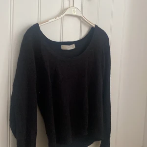 Svart stickad tröja med rund hals - En svart stickad tröja från Zara med rund, djup urringning och långa ärmar. Tröjan har en enkel och stilren design som passar perfekt till jeans eller kjol. Mjuk och skön att bära. 