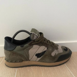 Valentino Rockrunner sneakers camouflage - Säljer dessa Snygga Valentino Rockrunner sneakers med camouflage-mönster i grönt, beige och svart för endast 1599. Box medföljer inte därav de låga priset. 