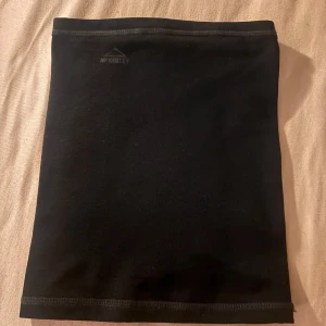 Svart fleecehalsduk från McKinley - En svart, enkel och stilren fleecehalsduk från McKinley. Tubmodell som sitter skönt runt halsen och håller dig varm under kalla dagar. Perfekt för dig som gillar en clean look utan mönster eller detaljer.