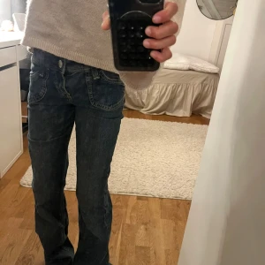 Blå bootcut jeans  - Snygga blå jeans. Bootcut-modell med låg midja. Jeansen har klassiska fickor fram och bak, ljus tvätt och kontrastsömmar. Perfekta för dig som gillar en avslappnad men trendig look.