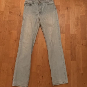 Ljusblå raka jeans från Nelly - Säljer ett par ljusblå jeans från Nelly med klassisk femficksdesign och raka ben. Jeansen har en enkel look med normal passform och är tillverkade i mjukt denimtyg. Perfekta för dig som gillar en avslappnad stil.