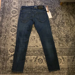 Mörkblå slim Jack & Jones jeans - Snygga och stilrena mörkblå jeans från Jack and Jones. Aldrig använda nypris 900 kr säljer dem för halva pris. En riktigt bra deal för ett par feta jeans. Storlek W29 och L30