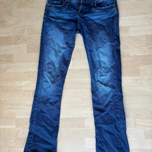 Blå bootcut jeans från LTB Valerie - Snygga bootcut och lowrise jeans från ltb i valerie modellen i en fin lite mörkare denimfärg och några små slitningar som detaljer, knappt använda, skriv vid frågor 💘