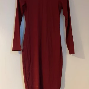 Vinröd långärmad klänning ZARA - Priset kan diskuteras. En enkel och stilren vinröd klänning med lång ärm och rak passform. Klänningen har en klassisk design utan mönster och når ungefär till knäna. Perfekt för dig som gillar minimalistisk stil och vill ha något bekvämt men snyggt.