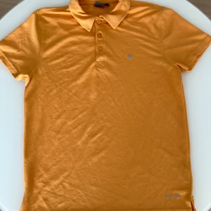 Gul pikétröja från Cross Sportswear - Snygg gul pikétröja från Cross Sportswear i storlek S. Tröjan har klassisk krage, tre knappar framtill och diskret logga på bröstet. Tillverkad i ett ventilerande bomullsmaterial som passar perfekt till mesta.