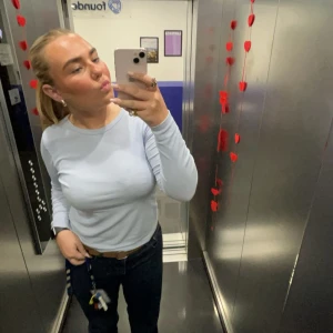 Ljusblå ribbad långärmad tröja H&M - Säljer en ljusblå långärmad tröja från H&M i ribbad bomull. Tröjan har en enkel, rund halsringning och sitter snyggt med normal passform. Perfekt att styla med jeans eller kjol för en clean look.