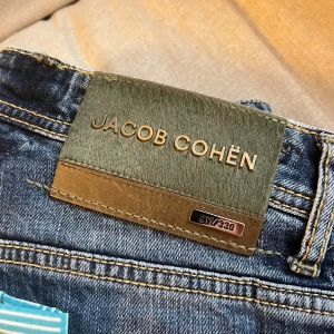 Jacob cohën jeans  - Jacob cohën jeans, , väldigt snygga jeans med en extremt clean back tag. Modellen bär W 32 och är 180 cm 75 kg, sitter perfekt på honom!  Måtten är A: 40 cm B:106 cm. Modell av jeansen är Bard Ltd . Vilket är en väldigt exklusiv modell. ✌️ gör ett bundle med produkten och få väldigt bra pris 🌟det går inte att ha skärp eftersom dom tyvärr är borttagna 