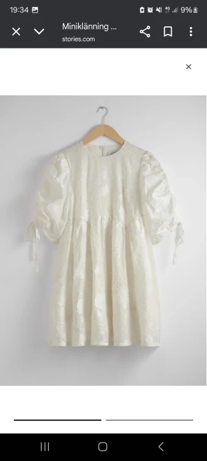 Babydoll studentklänning med prislapp kvar - Supersöt vit miniklänning med puffärmar och knytband vid ärmsluten. Klänningen har broderade blommor i tyget och en rund halsringning. Materialet känns lyxigt och har en lätt glans. Perfekt för dig som gillar romantiska detaljer och en feminin look. Passar perfekt till studenten, aldrig använd och prislappen finns kvar! Köptes för 1400kr och säljes inte längre! ❤️