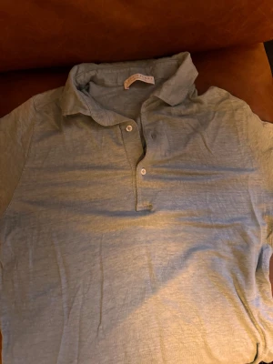 Ljusgrön piké från Luca Faloni - Snygg ljusgrön piké från Luca Faloni med klassisk krage och tre knappar framtill. Tillverkad i 100% linne som ger en avslappnad och cool vibe. Perfekt för dig som gillar stilrena och bekväma plagg.