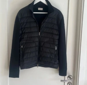 Svart Moncler pufferjacka S KVITTO FINNS - En svart cardigan i storleken S självklart äkta. Den är lite andvänd men den är i mycket bra skick det ända är att den är pyttelite skadad i handlederna men inget som påverkar eller syns alls! Kvitto finns samt en äktahets bevis varifiering och allt det nedkommer självklart vid köp!