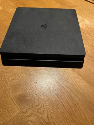 PlayStation 4 Slim - Sony PlayStation 4 Slim med tillhörande original DualShock 4-kontroll. Konsolen är i gott skick med mindre ytliga märken. Perfekt för gaming, streaming och underhållning. Alla portar hel. En utmärkt spelkonsol för både nya och erfarna spelare.