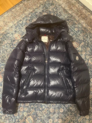 Moncler Maya - Stilig moncler Maya i en mörkblå färg som kommer i storlek 2/M, helt felfri i princip ny. För mer info eller bilder är det bara att höra av sig!